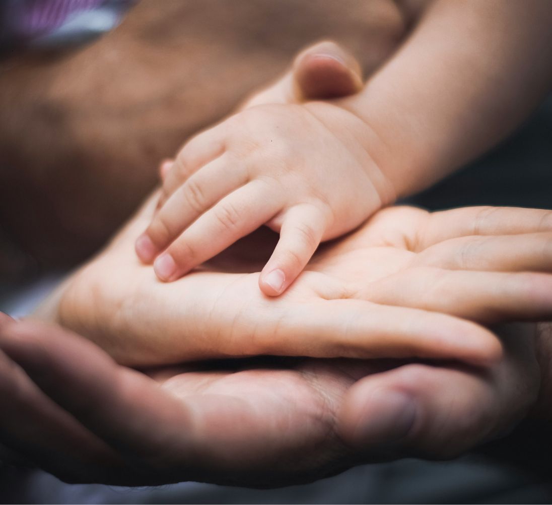 Mano di un bambino sulla mano di un genitore — legame transgenerazionale